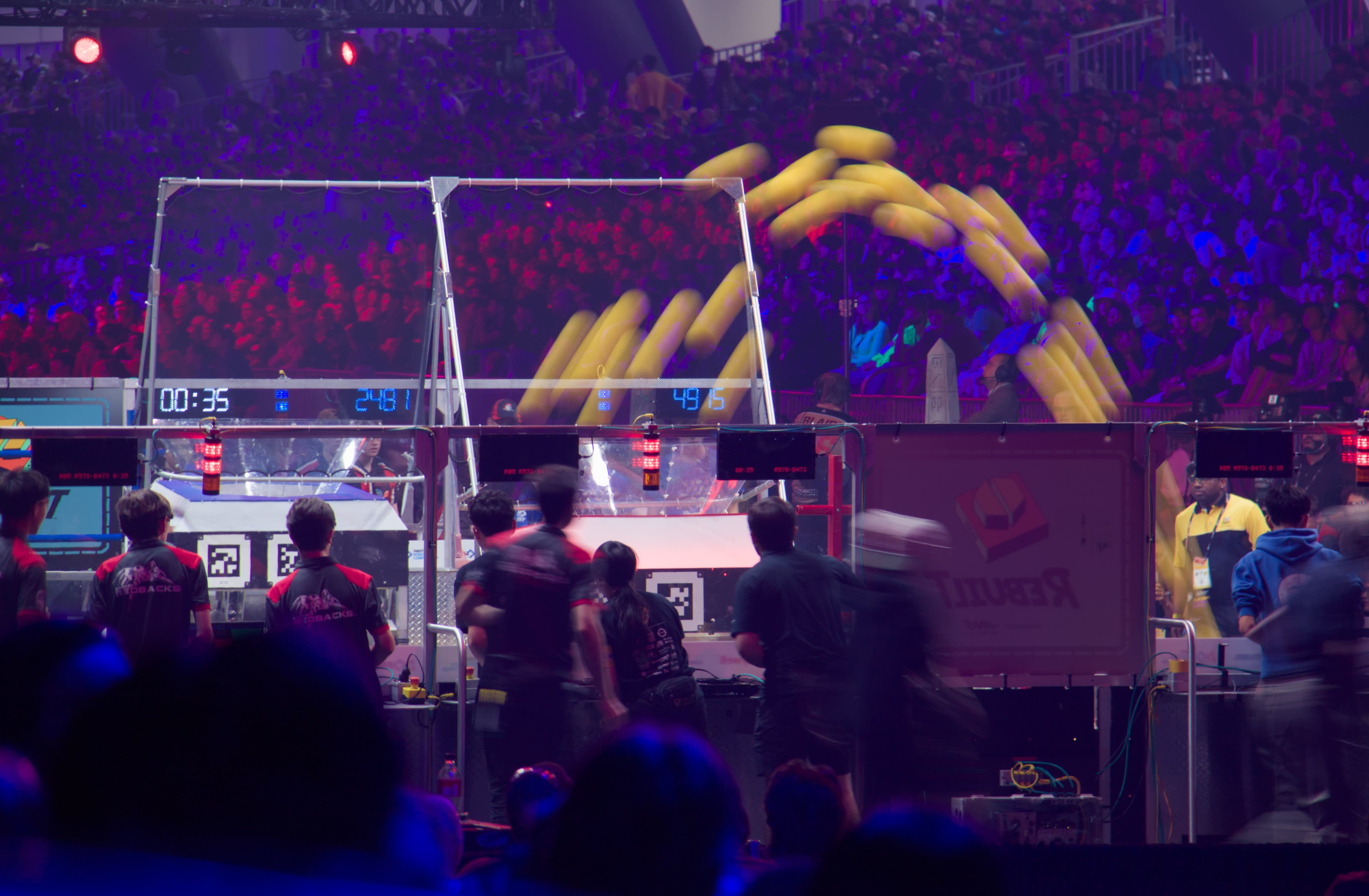 FIRST Robotics field with game pieces in motion